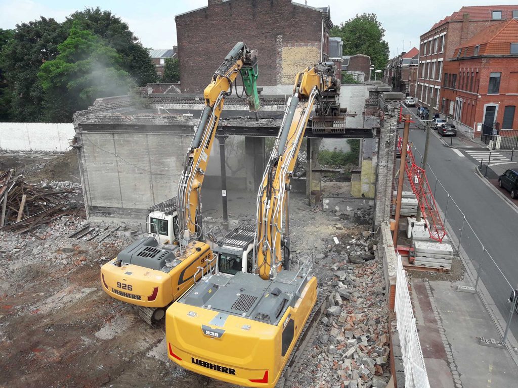 Chantier de démolition, désamiantage, curage, terrassement sur Tourcoing. Les terres et matériaux inertes ont été triés, concassés et recyclés in situ pour être réemployer directement sur le site. Helfaut Travaux - Nord